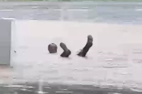 Homem mergulha em água de alagamento durante temporal em Cabo Frio